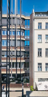 Berlin, Almanya - 13 Mayıs 2025: Modern kentsel binalarda güneş ışığını yansıtan cam cepheler ve çağdaş tasarım unsurları sergilenmektedir.