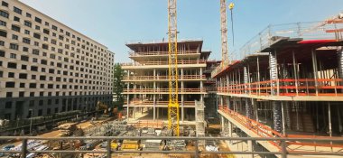 Berlin, Almanya - 02 Haziran 2025: İnşaat sahasında vinçler ve iskelesi geliştirilmiş yeni bir bina yer alıyor.