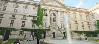 Berlin, Almanya - 02 Haziran 2025: Tarihi mimari kentsel bir ortamda bir çeşme ve yemyeşil alan içeriyor.