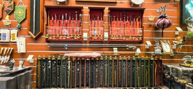 Berlin, Almanya - 13 Haziran 2025: Dekoratif kılıçlar ahşap rafları ve canlı renkleri olan bir dükkanda sergileniyor.