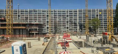 Berlin, Almanya - 13 Mayıs 2025: İnşaat sahasında turnalar ve şehir manzarasında devam eden inşaat gelişimi yer alıyor.