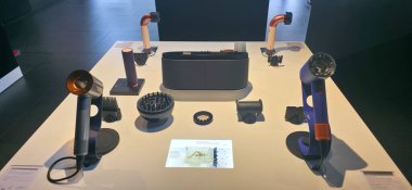 Berlin, Almanya - 17 Haziran 2025: Modern bir sergi salonundaki gösterişli bir masada yenilikçi saç şekillendirme araçları sergileniyor.