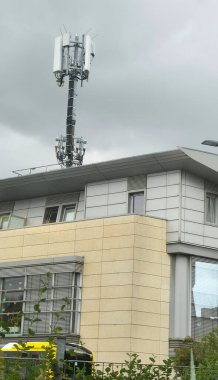 Berlin, Almanya - 27 Haziran 2025: Mobil ağ anteni bulutlu bir gökyüzünün altındaki modern bir binaya monte edilmiştir.