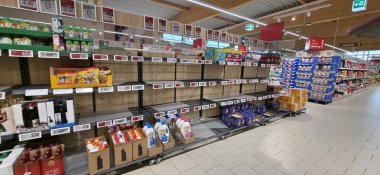 Berlin, Almanya - 28 Haziran 2025: Market koridorunda müşteriler için az sayıda ürün bulunan boş raflar gösteriliyor.