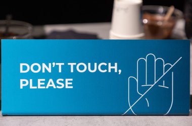 . Sign features a hand graphic and clear text, conveying a no-touching message in a modern design, suitable for various environments