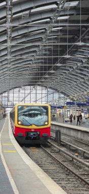 Berlin, Germany - July 21, 2025: . Modern train is arriving at a busy urban station with a stunning glass roof