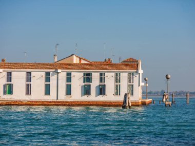 Murano, Venedik, İtalya Murano 29.10.2022 Kuzey lagün ve cam fabrikalarındaki ada. Gün batımında Venedik 'te Murano kanalları. Renkli eski evler ve köprüler kanal kıyılarını birbirine bağlıyor