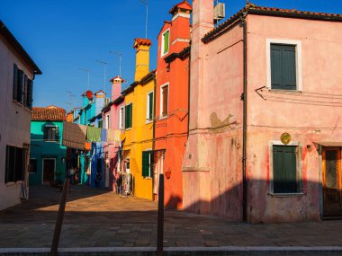 Burano, Venedik, İtalya 29.10.2022. Burano adası, Venedik bölgesi. Kanalların farklı taraflarındaki parlak renkli evler ve suda renkli yansımalar.
