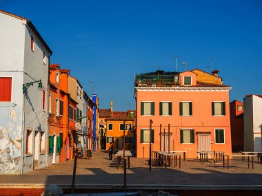 Burano, Venedik, İtalya 29.10.2022. Burano adası, Venedik bölgesi. Kanalların farklı taraflarındaki parlak renkli evler ve suda renkli yansımalar.