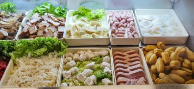 Taze malzemeler, çeşitli doku ve renklerin sergilendiği tepsilerde güzelce düzenlenmiştir. Mutfak hazırlığı ve sunumu için idealdir..