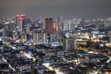Ufuk çizgisinde Kuala Lumpur 'un canlı şehir ışıkları ve şehir mimarisini gösteren gece görüntüsü.