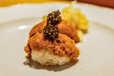 Zengin aromalı, havyarlı ve güzelce süslenmiş gurme suşi, zarif bir tabakta sunuluyor, mutfak sanatını gözler önüne seriyor..