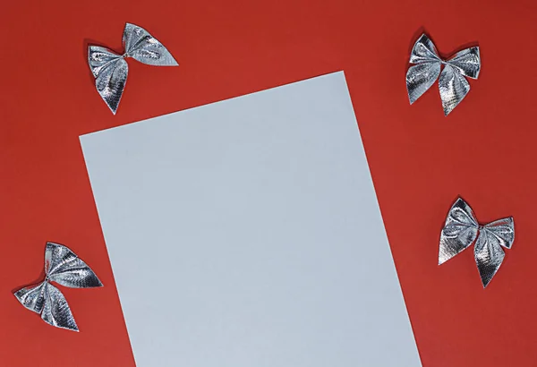 Белый Лист Бумаги Красном Фоне Бантами Серебряной Фольги — стоковое фото