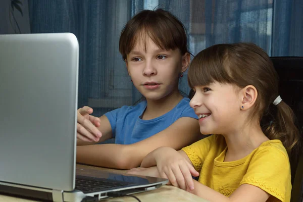 소녀가 노트북을 보면서 웃습니다 가정에서의 학습의 — 스톡 사진