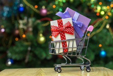 İçinde paketlenmiş tatil kutuları olan market alışveriş arabası.