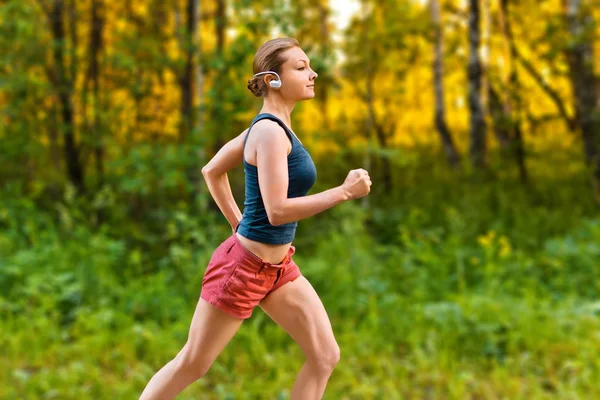 Young sport woman runs on the road — Stock Photo, Image