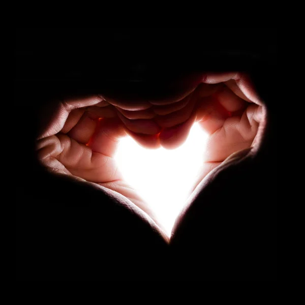 Hands  in backlight make the shape of heart — Stock Photo, Image