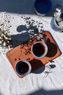 Masanın üzerinde bir fincan koyu kahve ve kahve çekirdeği..