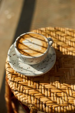 Tahta masadaki sıcak latte sanat kahvesine odaklan, beyaz köpüğe odaklan.