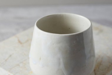 Gri arka plandaki seramik bardağı kapat, stüdyo ışığı