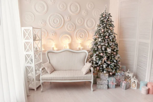 白いソファが飾られたリビングルームのインテリアシックなクリスマスツリー ギフト 毛皮の木の装飾 白い壁とクリスマスのインテリア クリスマスプレゼントと新年の木で内装 — ストック写真