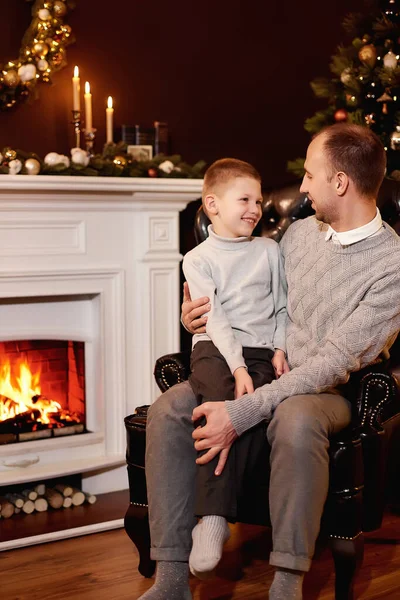 Ojciec Synem Siedzą Fotelu Przy Choince Kominku Patrząc Siebie Świąteczny — Zdjęcie stockowe