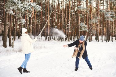 Xmas günaydın. Mutlu çift, kar parkında eğleniyor. Karlı Çam Ormanı 'na kar atıyor, eğleniyor ve eğleniyor. Aktif kış tatili, Noel tatilini birlikte geçirmek.