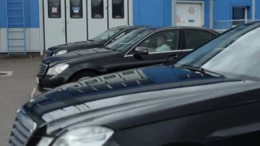 Minsk, Belarus - 17 Eylül 2020: Aynı model lüks siyah Mercedes arabaları aynı hızda ve aynı mesafede gösteri alanı boyunca aynı sırada sürüyorlar.
