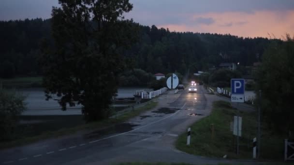 Gomel, Belarus - 28 Ağustos 2020: Farları açık arabalar, arka planda orman ve günbatımı olan bir köprü boyunca ilerliyorlar — Stok video