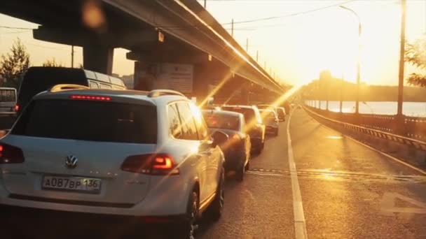 Rostov-on-Don, Rusko - 17. září 2020: Pohled z kokpitu auta jedoucího přes most na racka letícího nad vodou a vysoké domy na pozadí západu slunce — Stock video