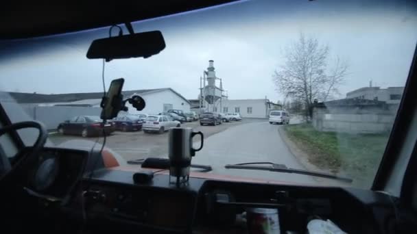 Rostov-on-Don, Rusland - 17 september 2020: Een jongeman rijdt in een bestelwagen en rijdt langs staande auto 's in de buurt van opslagfaciliteiten en een onafgewerkt gebouw. In de cabine — Stockvideo