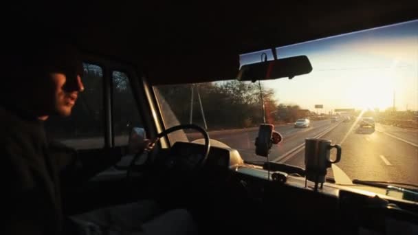 A young man drives his van on a busy road and enters an industrial area of a big city. View from inside the cab — Αρχείο Βίντεο