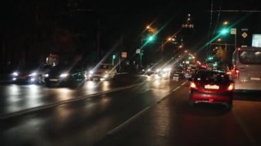 Rostov-on-Don, Rusya - 17 Eylül 2020: Trafik ışıkları, sokak lambaları ve siyah ev siluetleri ile büyük bir şehir yolunda yoğun gece trafiği