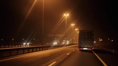Otoyoldaki çeşitli araçların gece trafiği ve köprüsü olan bir kavşak. Yolculuk