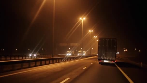 Upptagen natttrafik av olika fordon på motorvägen och en vägkorsning med en bro. Vägresa — Stockvideo