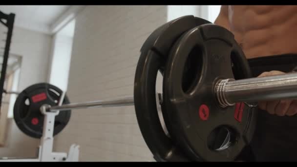 Νεαρός bodybuilder κάνει πάτημα πάγκου με ένα κουδούνι στην εκπαίδευση στο γυμναστήριο και κουνάει τους θωρακικούς μυς και τρίφτες — Αρχείο Βίντεο