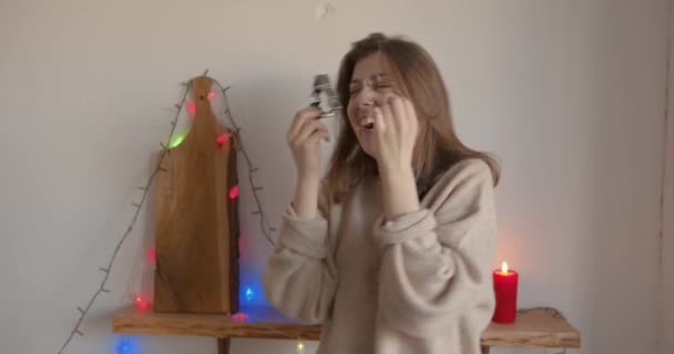 Wesoła młoda dziewczyna gotowanie piernika na Boże Narodzenie i wygłupianie się w kuchni trzymając nożyce do ciasteczek w pobliżu oczu jak okulary i taniec. Zwolniony ruch — Wideo stockowe