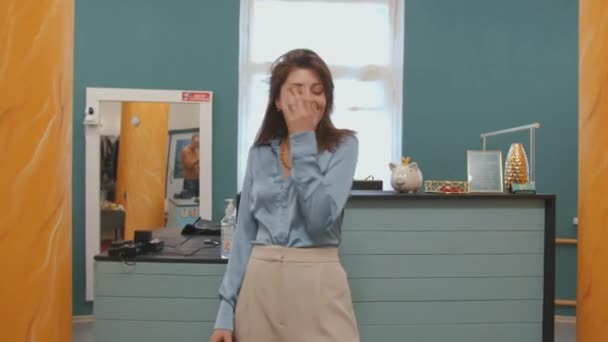 Schattig jong meisje demonstreert een modieuze strik in een kledingwinkel en komt in de paskamer de gordijnen dicht doen — Stockvideo