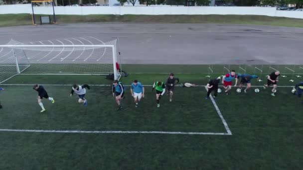Misk, Belarus - 15 Ağustos 2020: Futbol takımı antrenmanı sırasında futbol sahasında hızla koşan atletlerin insansız hava aracı görüntüleri — Stok video