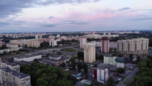 Bir yaz akşamı gökyüzünde ay ve stadyumda futbol oynayan atletlerin olduğu şehir panoramasının insansız hava aracı çekimi. — Stok video