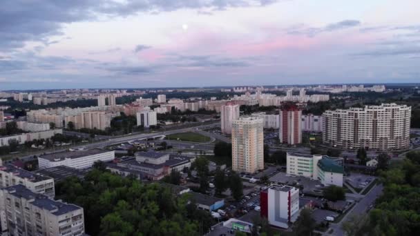 Disparo de aviones no tripulados del panorama de la ciudad con la luna en el cielo en una noche de verano y los atletas jugando fútbol en el estadio — Vídeo de stock