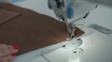 Döşeme mobilyalarının tamiri için bir atölyedeki profesyonel dikiş makinesinin dikiş işlemini kapat