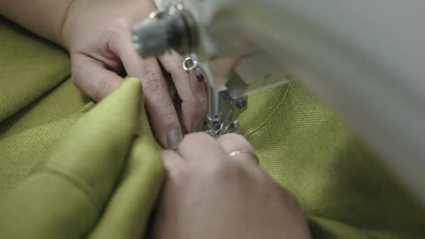 Женщина пришивает профессиональную швейную машинку в мастерской по ремонту мягкой мебели и шьет материал для дивана — стоковое видео