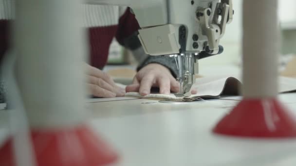 Primer plano de una mujer manos en el trabajo en una máquina de coser en un taller de reparación de muebles tapizados — Vídeos de Stock