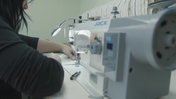 Misk, Belarus - 15 Mayıs 2020: Bir kadın profesyonel bir dikiş makinesinde çalışıyor ve döşenmiş mobilya tamir atölyesinde kumaş parçaları dikiyor — Stok video