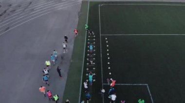 Misk, Belarus - 15 Ağustos 2020: Futbol sahasında antrenman yapan ve engellerin üzerinden atlayan futbolcuların kuş bakışı görüntüsü