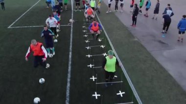 Misk, Belarus - 15 Ağustos 2020: Bir yaz akşamı stadyumda futbol takımı antrenmanının en iyi görüntüsü. Oyuncular engellerin üzerinden atlar