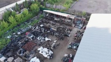 Bir yaz günü açık hava deposunda araba için farklı yedek parçaları olan rafların ve paletlerin üst görüntüsü