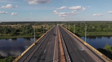 Bir yaz gününde mavi gökyüzüne karşı trafik ve şehir panoramalarıyla nehir üzerinde bir yol köprüsünün insansız hava aracı vurulması.