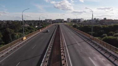 Nehrin karşısındaki köprüdeki trafik manzarası güneşli bir yaz gününde yeşil kıyılar arasında.